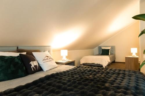 a bedroom with two beds and two lamps at Alpejski Zieleniec in Duszniki Zdrój