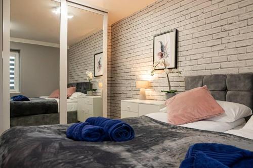 a bedroom with two beds and a brick wall at Detached 2 Bedroom House - 10 minute's walk to Town Centre - Free Parking, Fast Wifi and Smart TVs by Tejza Property in Rugby
