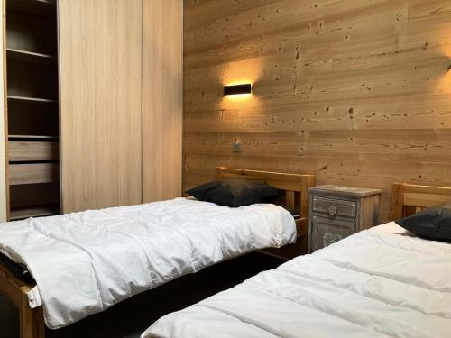 deux lits dans une chambre aux murs en bois dans l'établissement La Residence - Appartement La Résidence MAE-9501, à Vénosc