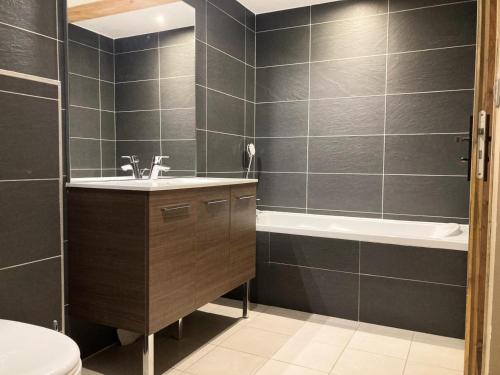 une salle de bain avec un lavabo, une baignoire et des toilettes dans l'établissement La Residence - Appartement La Résidence MAE-9501, à Vénosc