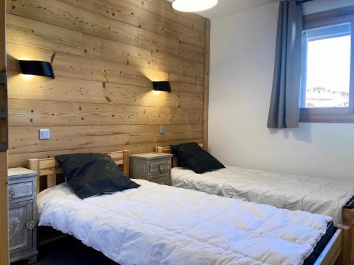 deux lits dans une chambre aux murs en bois dans l'établissement La Residence - Appartement La Résidence MAE-9701, à Vénosc