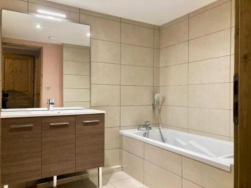 une salle de bain avec un lavabo, une baignoire et un miroir dans l'établissement La Residence - Appartement La Résidence MAE-9711, à Vénosc