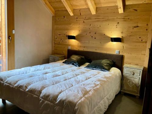 une chambre avec un grand lit avec un mur en bois dans l'établissement La Residence - Appartement La Résidence MAE-9721, à Vénosc