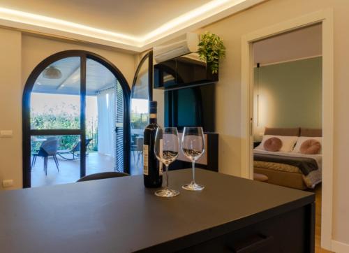 two wine glasses sitting on a table in a room at HOLIDAYS HOMES ROME GOLF Appartamenti Marco Simone AeB in Marco Simone