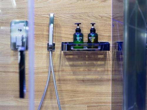two bottles of soap on a shelf in a bathroom at HOLIDAYS HOMES ROME GOLF Appartamenti Marco Simone AeB in Marco Simone