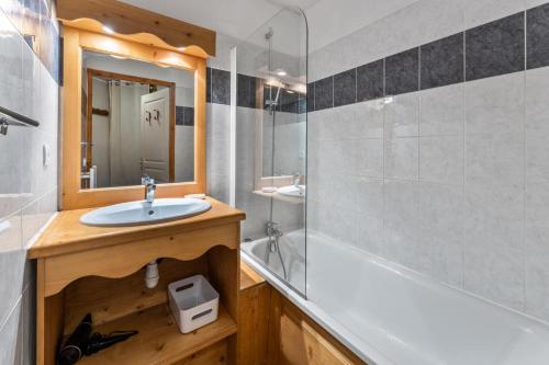 une salle de bain avec un lavabo, une baignoire et un miroir dans l'établissement Résidence Les Hauts De Preclaux - Appartement calme et chaleureux face aux pistes MAE-4391, aux Orres