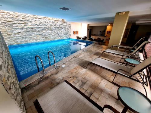 a swimming pool with tables and chairs next to it at Torre Sol ll Trade Center 411Mall del Sol Ecusuites Gye in Guayaquil