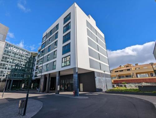 a large white building with a street in front of it at Top-Floor One-Bedroom Flats - Peaceful with Ocean and City Views in Funchal
