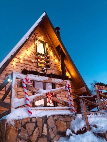 a log cabin with christmas lights on the window at Planinska kuća Isiteo in Kremna