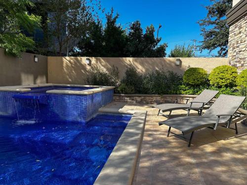 a swimming pool with two chairs and a swimming pool at Best Western PREMIER Monterrey Aeropuerto in Monterrey