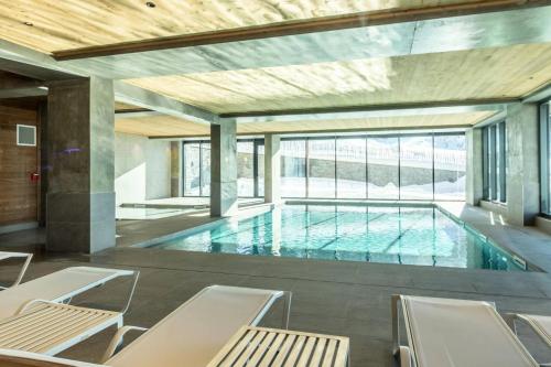 - une grande piscine avec des chaises dans une maison dans l'établissement Résidence Le Ridge - RIDGE 107 MAE-5031, à Arc 1600