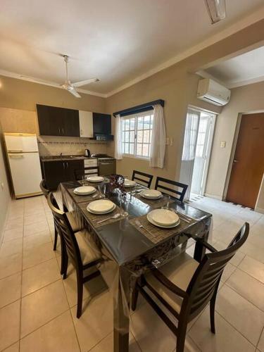 a dining room with a table and chairs and a kitchen at Amplio Departamento Céntrico in Formosa