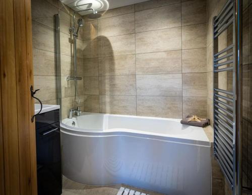 a white bath tub in a bathroom at Tractor Shed, seaside cosy cottage for 4 in Beaumaris