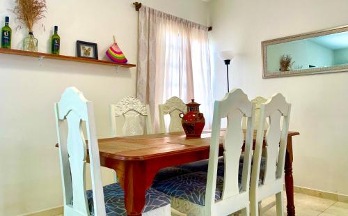 a dining room table with chairs and a vase on it at EXCELENTE CASA PRIVADA, ASADOR, JARDÍN, ESTACIONAMIENTO & ac in Ciudad Valles