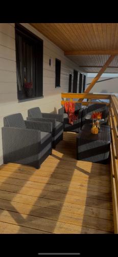a patio with couches and chairs on a deck at Gîte duplex les Glycines in Bennwihr