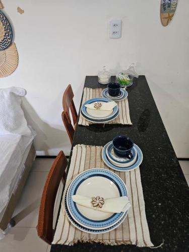 a table with two plates and bowls on it at FRENTE MAR - Cumbuco - Eco Paradise in Cumbuco
