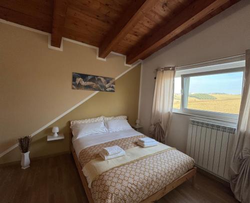 a bedroom with a bed and a large window at IL GLICINE CAMPAGNOLO in Atessa