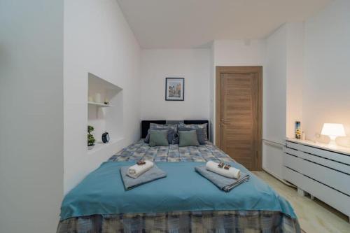 a bedroom with a blue bed with two towels on it at Jordan Belgrade Apartment in Belgrade