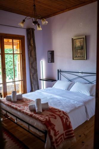 a bedroom with a large bed with white sheets at Vila Elati Oreini Korinthia in Velína