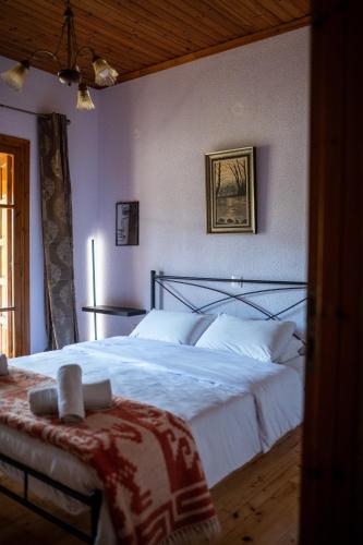a bedroom with a large bed with white sheets at Vila Elati Oreini Korinthia in Velína