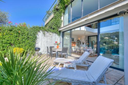 un patio avec des chaises et des tables blanches et une fontaine dans l'établissement Semiramis at Villa Laurie - Happy Rentals, à Mougins