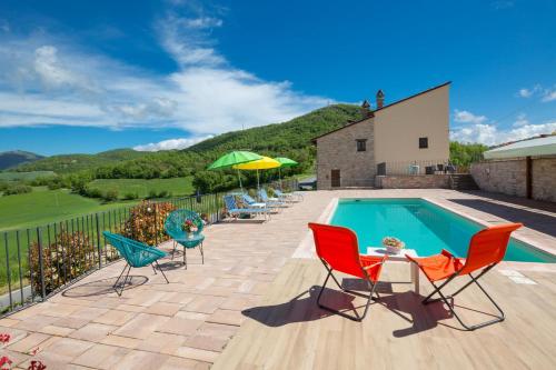 a patio with chairs and a swimming pool at Agriturismo I CASALI DI MORRO in Sellano