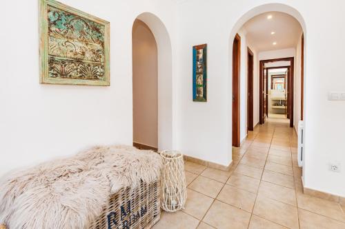 a hallway with white walls and a couch in a room at Casa Colom in Portocolom