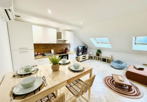 une cuisine et un salon avec une table et des chaises dans l'établissement Appartement climatisé-Centre Ville-Gare, à Reims