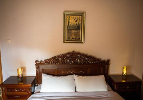 a bed with a wooden headboard and two nightstands sidx sidx sidx sidx at Vila Elati Oreini Korinthia in Velína