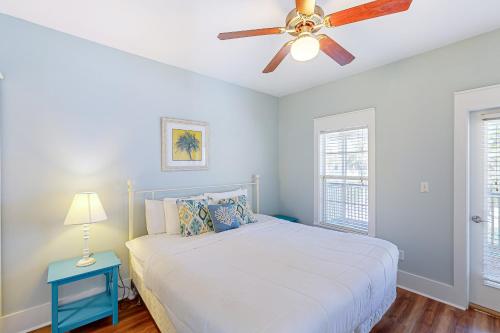 une chambre avec un lit et un ventilateur de plafond dans l'établissement Barefoot Cottages #B22, à Highland View