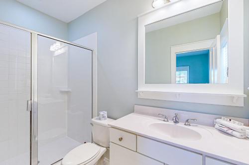 une salle de bain avec toilettes, lavabo et miroir dans l'établissement Barefoot Cottages #B22, à Highland View