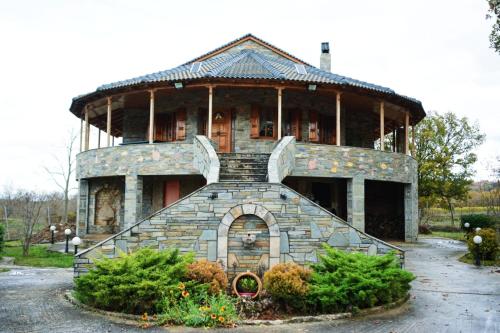 a large building with a stone staircase in a yard at Vila Elati Oreini Korinthia in Velína