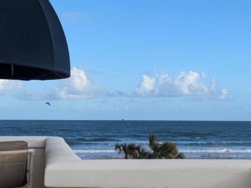 a couch sitting on the beach with the ocean at Oceanfront 2br2b, Ocean Views, Heated Pool, Spa in Cape Canaveral