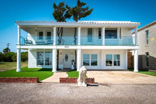 a white fire hydrant in front of a house at Oceanfront Retreat 2 Homes for 29-Guests in Corpus Christi
