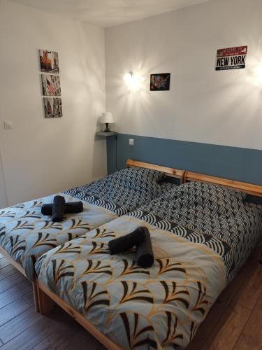 une chambre avec un lit avec deux chaussures dessus dans l'établissement L'Atypick - meublé de tourisme 4 étoiles, à Saint-Sauveur