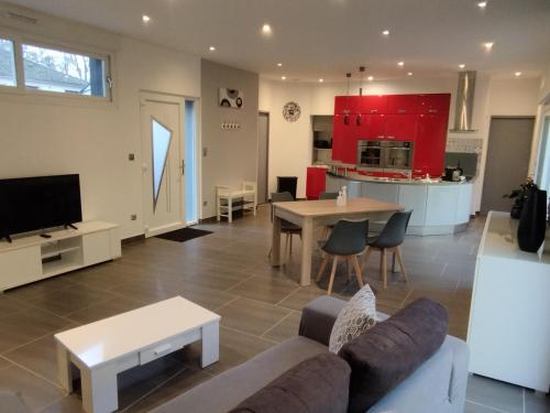 un salon et une cuisine avec un canapé et une table dans l'établissement L'Atypick - meublé de tourisme 4 étoiles, à Saint-Sauveur