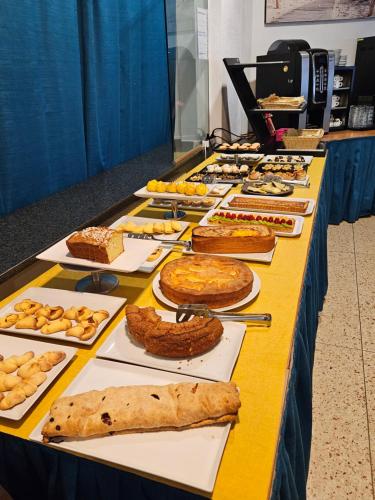 a table filled with different types of pies and pastries at Hotel Villa Camilla in Varazze