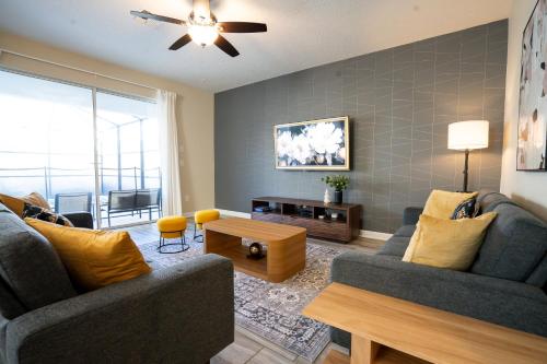 a living room with two couches and a tv at Storey Lake Pool Home with Resort Amenities near DISNEY in Kissimmee