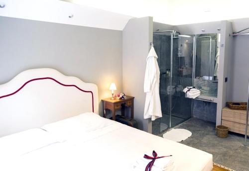 a bedroom with a white bed and a shower at La Luna e i Faló Luxury Accomodation in Turin