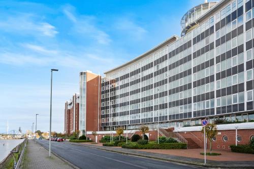 an empty street in front of a large building at Strand-Apartment, Strandkorb, Meeresrauschen, Parkplatz in Wilhelmshaven