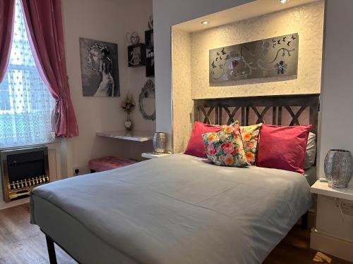 a bedroom with a large bed with red pillows at Maria in London