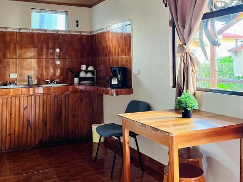 a kitchen with a wooden table and chairs in a room at Los Tucanes Lodging in El Castillo de La Fortuna