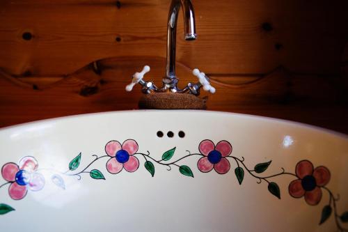 a bath tub with flowers painted on it at Log Cottage KUROITA in Hakuba