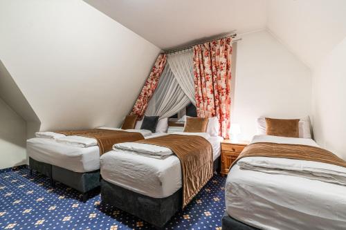 a bedroom with three beds and a window at Dunajecki Dworek in Zakopane