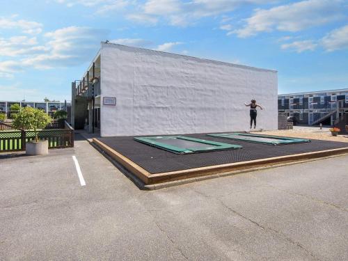 a person standing on a trampoline in a parking lot at 6 person holiday home in Glesborg in Glesborg
