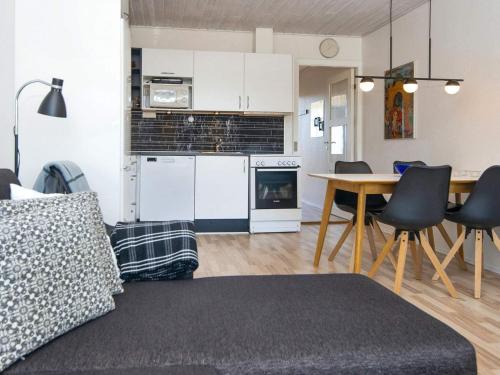 a living room with a kitchen and a table with chairs at Holiday home on a holiday park in Glesborg in Glesborg