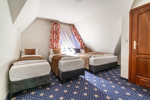 a small room with two beds and a window at Dunajecki Dworek in Zakopane
