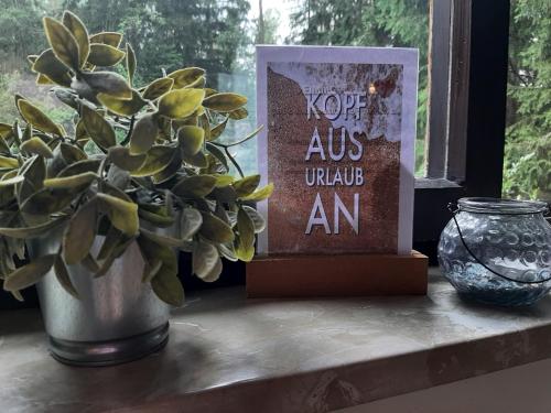 a book sitting on a window sill next to a plant at Bungalow direkt am See, mit eigenem Boot in Roding