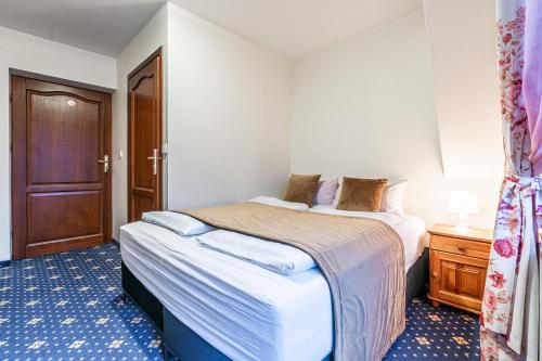 a bedroom with two beds and a wooden door at Dunajecki Dworek in Zakopane