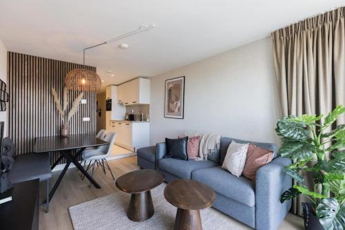 a living room with a blue couch and a table at Haya Seaview - The Casino in Scheveningen